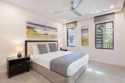 a bedroom with a large bed and two windows at The Oasis at Temple - A Rooftop Resort Retreat in Port Douglas