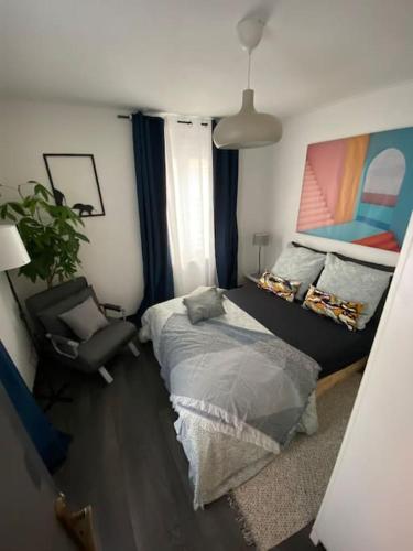 une chambre avec un lit et une chaise dans l'établissement Appartement privé 2 pièces 42m proche centre, à Schiltigheim