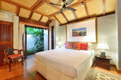 a bedroom with a large white bed in a room at Paradiso Pavilion - An Intimate Bali-style Haven in Port Douglas