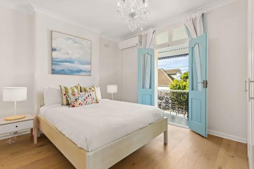 a bedroom with a bed with blue doors and a window at Henrietta - Poolside Relaxation near Bronte Beach in Sydney