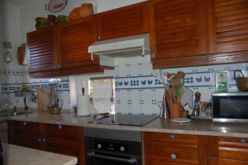 a kitchen with wooden cabinets and a stove top oven at Isa's Home in Sintra