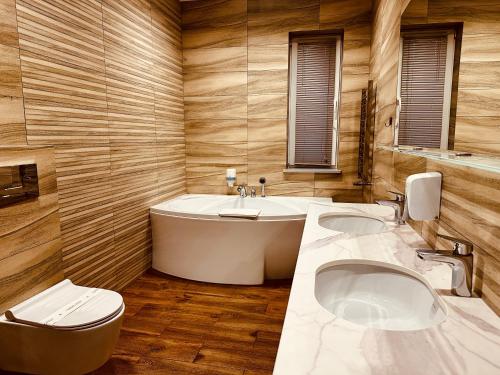 a bathroom with two sinks and a tub and a toilet at Hotel Rubin in Stara Blotnica