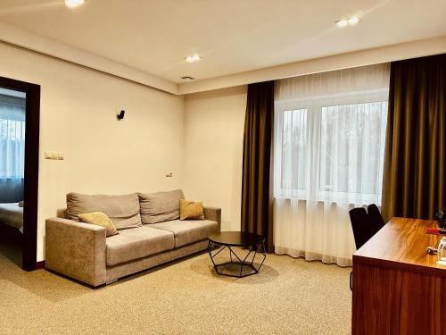 a living room with a couch and a table at Hotel Rubin in Stara Blotnica