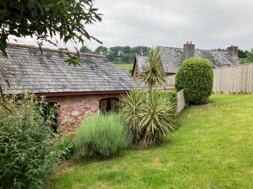 an old stone house in a yard with plants at Barn conversion near the coast in Paignton