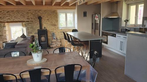 cocina y sala de estar con mesa y sillas en La Grange du Pradel, en Montredon-Labessonnié