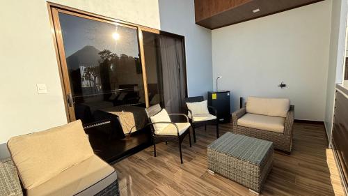 a living room with chairs and a couch and a table at Arenal Monara in Fortuna
