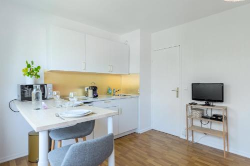 une cuisine avec une table avec des chaises et une télévision dans l'établissement Croisé Laroche equipped studio!, à Marcq-en-Barœul