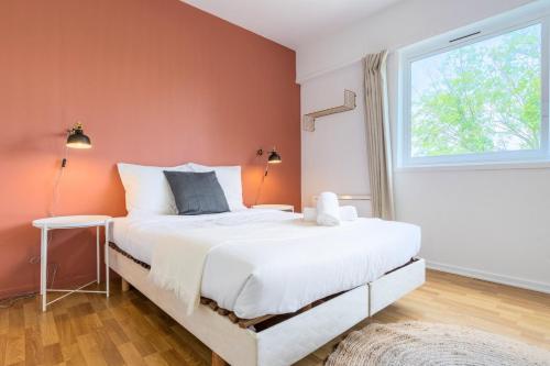 een slaapkamer met een groot bed en een raam bij Croisé Laroche equipped studio! in Marcq-en-Baroeul