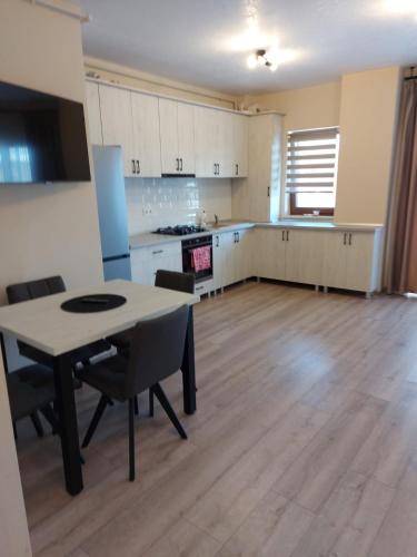 an empty kitchen with a table and chairs in a room at Apartament 1 in Bistriţa
