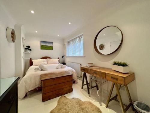 Schlafzimmer mit einem Bett, einem Spiegel und einem Schreibtisch in der Unterkunft Ground floor central apartment in Kingsbridge