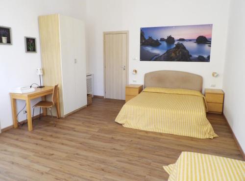 een slaapkamer met een bed en een bureau en een bed bij B&B Stella Marina in Acitrezza