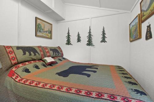 um quarto com uma cama com um cobertor com um urso em New Riverfront property Sasquatch Cabin em Fleetwood
