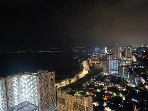 a view of a city at night with the ocean at Urban Suites 3 Rooms, Cat Theme & Romantic in Jelutong