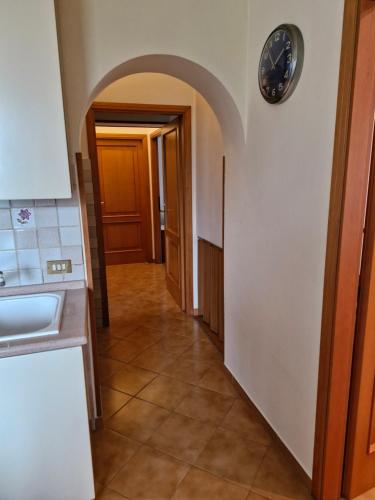 un corridoio in una cucina con un orologio sul muro di casa vacanze sweet home a San Giovanni in Marignano