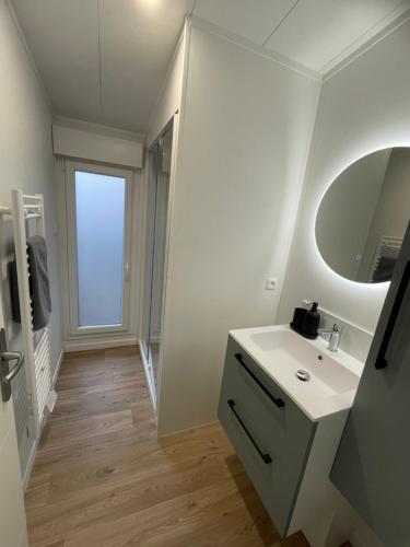 a white bathroom with a sink and a mirror at Camping Paradis de Maillac in Sainte-Nathalène