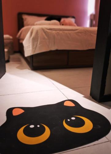 a black cat rug on the floor in a bedroom at Urban Suites 3 Rooms, Cat Theme & Romantic in Jelutong
