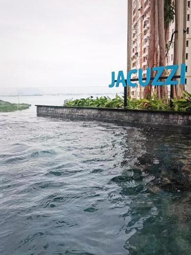 a large body of water next to a large building at Urban Suites 3 Rooms, Cat Theme & Romantic in Jelutong