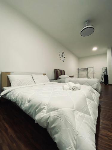 1 cama blanca grande en un dormitorio con suelo de madera en Comfy suites, en Donggongon