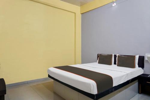 ein Schlafzimmer mit einem Bett in einem Zimmer in der Unterkunft Collection O HOTEL DAULAT INN in Lonavla