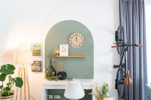 a room with a desk with a clock on the wall at Residenz - Pedelec - Penthouse - Sauna - Parkplatz in Bad Zwischenahn