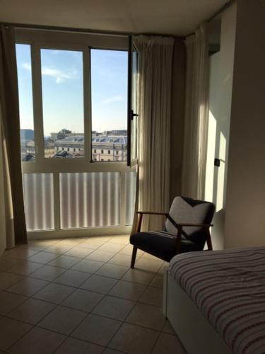 una camera con un letto e una sedia e una finestra di flat in Padova center a Padova
