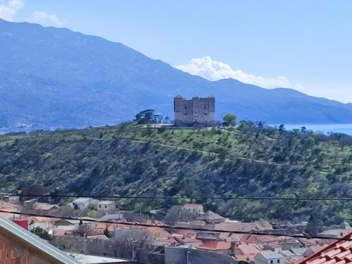 un château au sommet d'une colline avec une montagne dans l'établissement sanya, à Senj