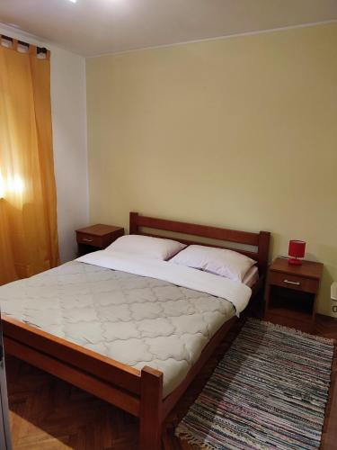 Ce lit se trouve dans une chambre dotée de 2 tables de chevet et de 2 tables. dans l'établissement sanya, à Senj