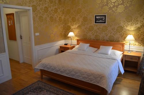 レドニツェにあるZamecky Hotel Ledniceのベッドルーム1室(ベッド1台、ランプ2つ、テーブル2台付)
