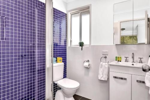 a blue tiled bathroom with a toilet and a sink at Blue Cabin Bliss at Aldinga Bay Holiday Village in Aldinga Beach