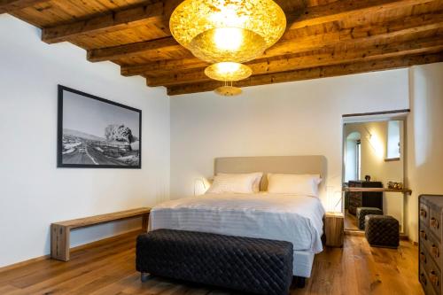 1 dormitorio con cama y lámpara de araña en Relais Villa Carrara, en Villa di Serio
