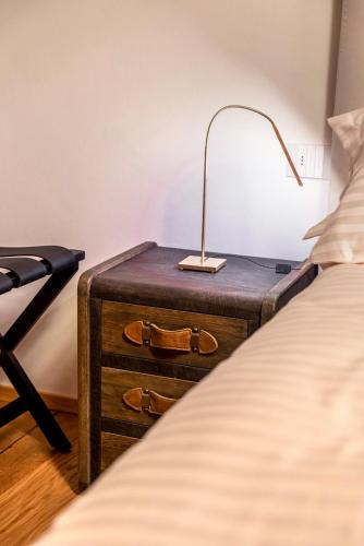 a lamp on a table next to a bed at Relais Villa Carrara in Villa di Serio