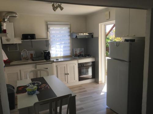 eine Küche mit einem weißen Kühlschrank und einem Tisch mit Stühlen in der Unterkunft villa les mimosas in Antibes