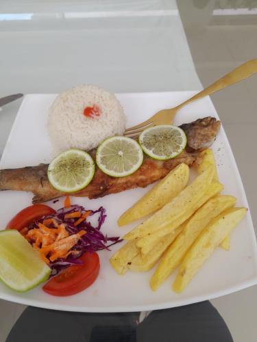 een bord met vis, groenten en rijst bij HOTELERIA CASA MAYA in Riobamba