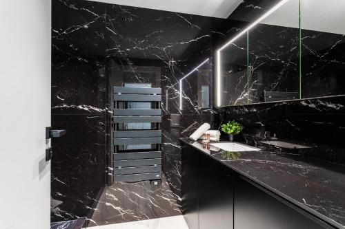 Baño de mármol negro con lavabo y espejo en Résidence Gray d'Albion Studio DEL562, en Cannes