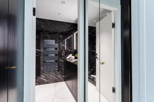 baño con paredes de mármol negro y espejo en Résidence Gray d'Albion Studio DEL562, en Cannes
