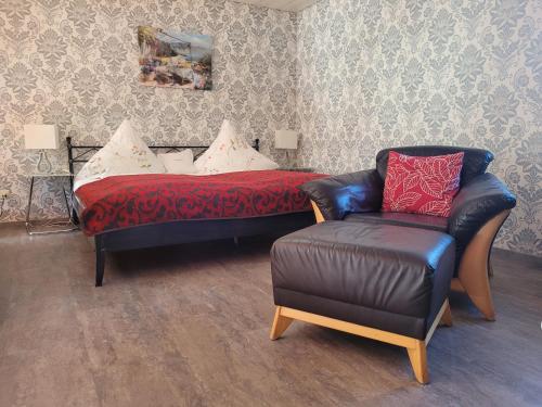 a bedroom with a bed and a chair and a couch at Apartments Fischerklause am Bodensee in Wasserburg am Bodensee