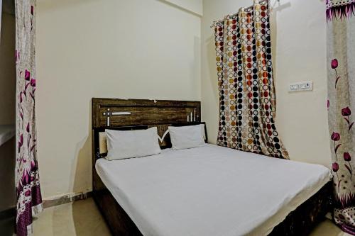 sypialnia z dużym białym łóżkiem w pokoju w obiekcie OYO The Dream Restaurant & Cafe w mieście Nārnaul