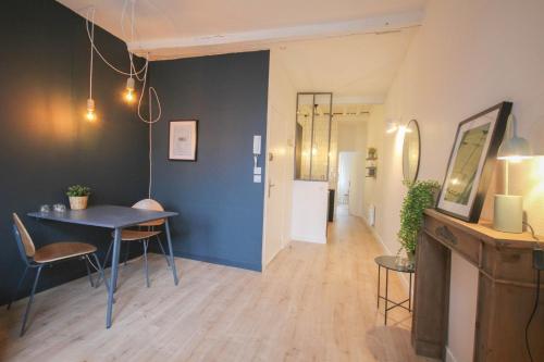 Cette chambre est dotée d'une table, de chaises et d'un mur bleu. dans l'établissement In the heart of Old Lille: Rue de la Monnaie, à Lille