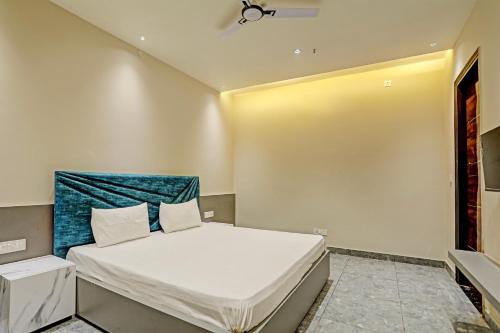 a bedroom with a bed with a blue headboard at OYO Miraas Hotel And Banquet Hall in Ludhiana