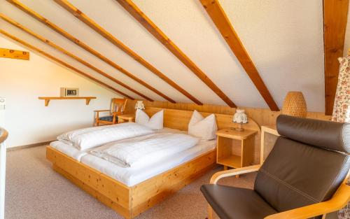 ein Schlafzimmer mit einem Holzbett und einem Stuhl in der Unterkunft Gästehaus Hagen in Reit im Winkl