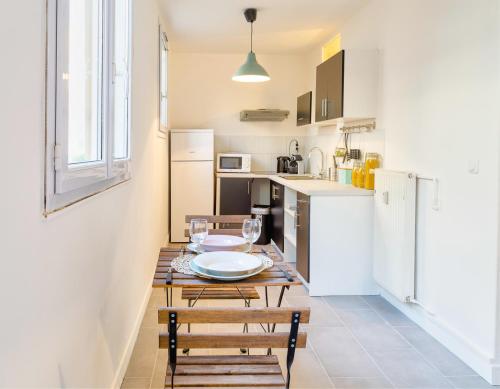 uma cozinha com uma mesa e cadeiras e um frigorífico em Budget studio near Paris em Gennevilliers