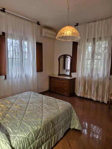 1 dormitorio con cama y lámpara de araña en casa vacanze sweet home, en San Giovanni in Marignano