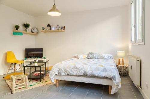 um quarto com uma cama, uma mesa e uma televisão em Budget studio near Paris em Gennevilliers