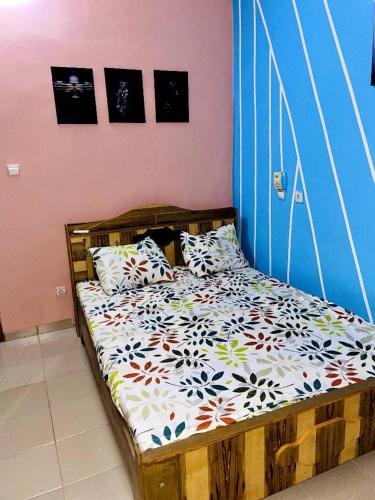 1 dormitorio con cama de madera y almohadas en As résidence meublée en Uagadugú