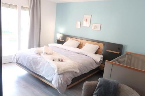 a bedroom with a large bed with white sheets at C A L M au Cœur du Valais in Riddes