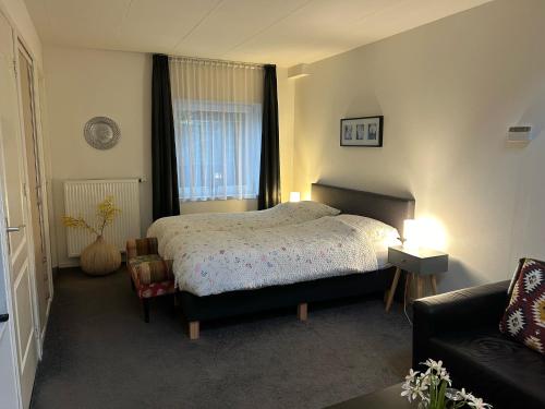 Stevensweert的住宿－Vakantie Appartementen Engelen，一间卧室配有一张床和一张沙发