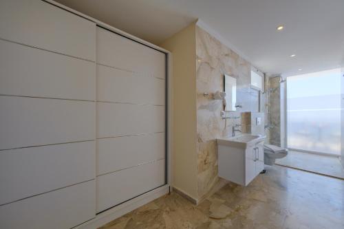 a white bathroom with a toilet and a sink at Lumiere Villas 2 in Kalkan
