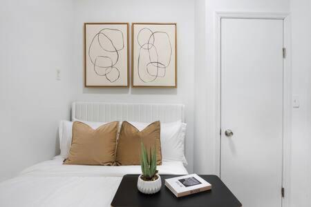 a bedroom with a bed and a table with a plant at 91-2A Stylish 3BR 2Bth with W D in New York