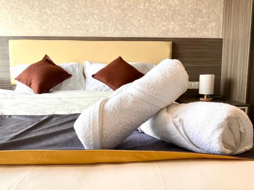 a bed with white towels and pillows on it at HillLand Suites in Ayer Keroh