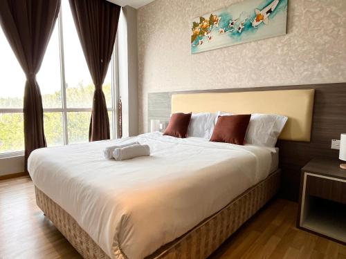 a bedroom with a large bed with a large window at HillLand Suites in Ayer Keroh